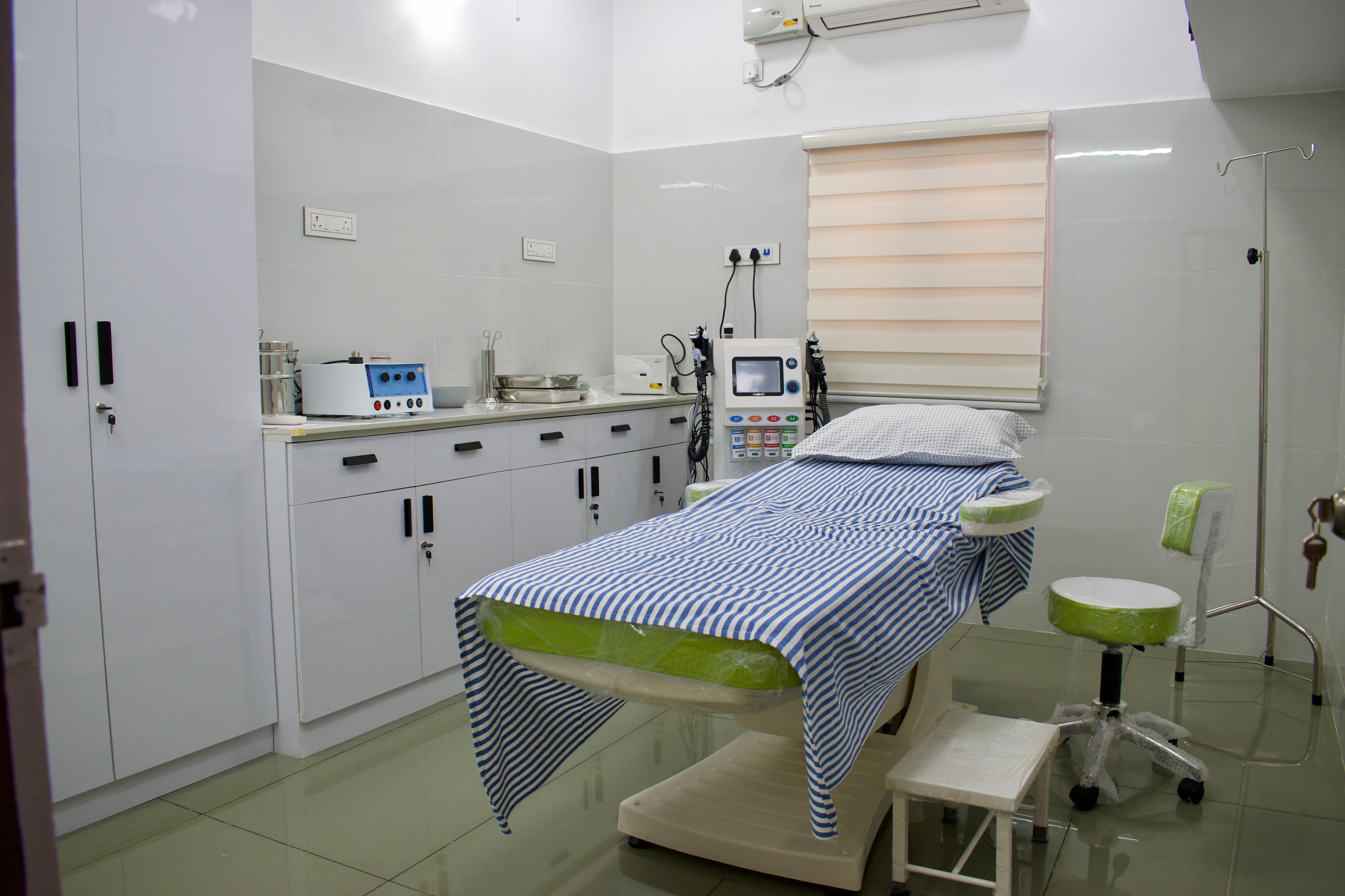 Treatment room with dermatology equipment at Ann Santhosh Skin Clinic